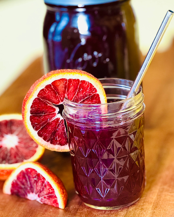 Glass of kvass with orange slice and straw