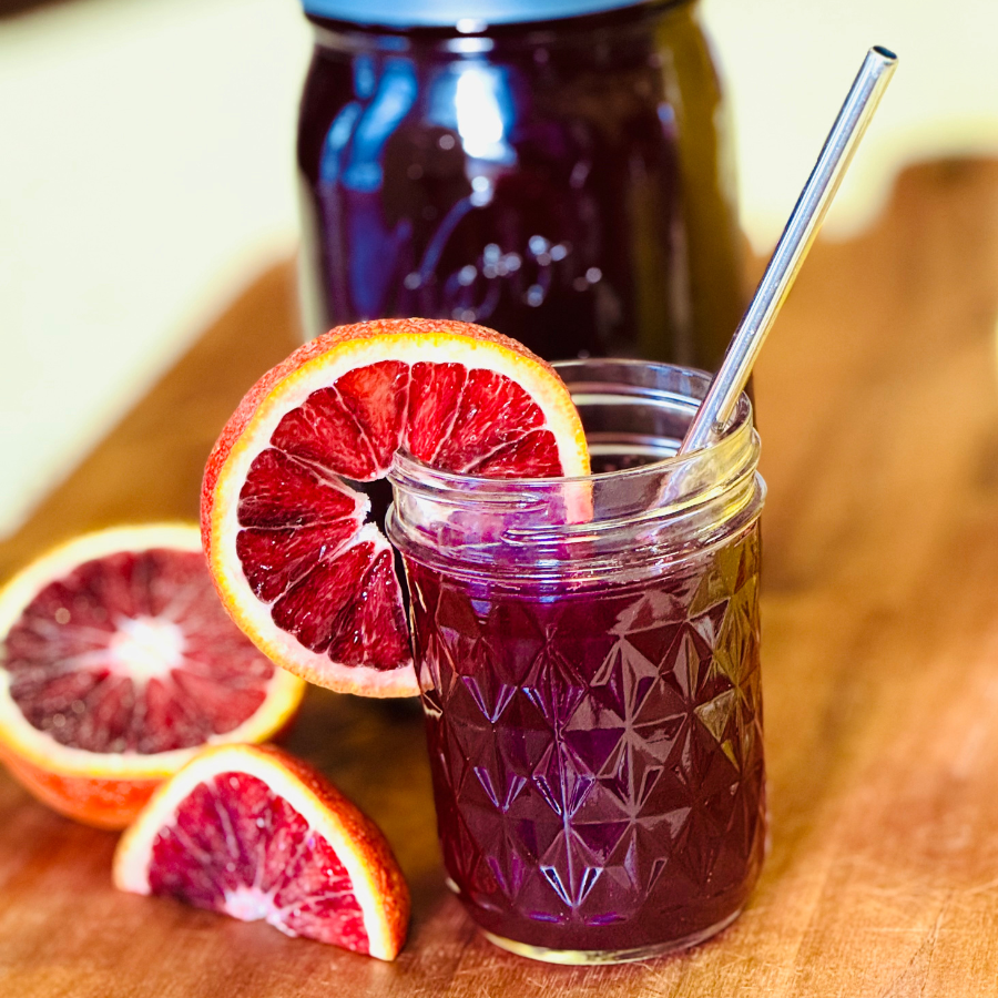 Glass of kvass with orange slice and straw